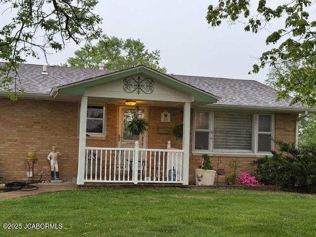 200 Sondra Ave, Columbia, MO 65202 - view of front of house with covered porch, brick siding, roof with shingles, and a front yard