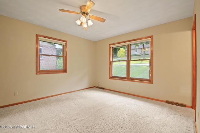 1101 E Maplewood Ct, Jefferson City, MO 65109 - spare room featuring carpet, baseboards, and a ceiling fan