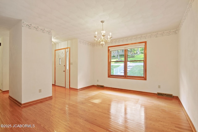 1101 E Maplewood Ct, Jefferson City, MO 65109 - empty room featuring light wood-style flooring, a chandelier, and baseboards