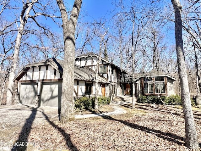 view of front of house featuring driveway, a sunroom, an attached garage, and brick siding