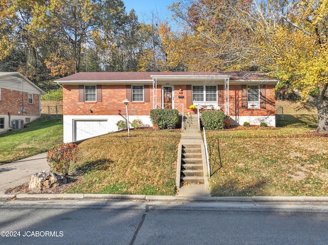 view of front of house featuring a garage, a front yard, and central AC