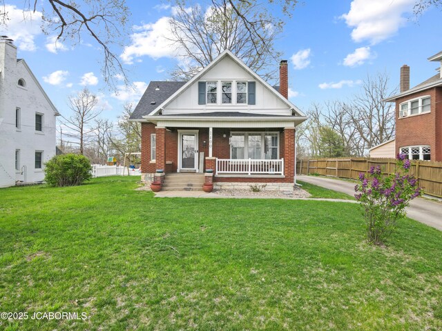1400 W Main St, Jefferson City, MO 65101 - view of front facade with brick siding, a chimney, covered porch, and roof with shingles