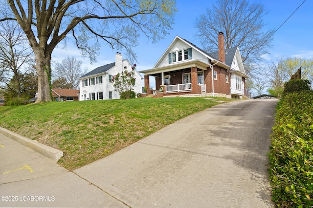 1400 W Main St, Jefferson City, MO 65101 - bungalow-style home featuring brick siding, a porch, a front yard, and a chimney