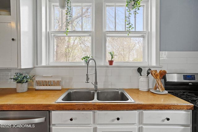 1400 W Main St, Jefferson City, MO 65101 - kitchen featuring stainless steel appliances, tasteful backsplash, and white cabinets