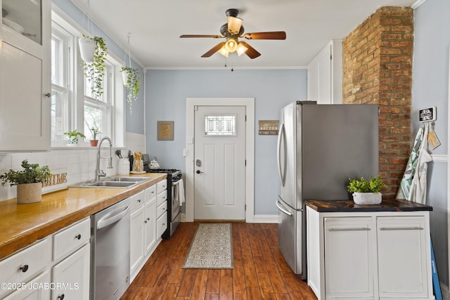 1400 W Main St, Jefferson City, MO 65101 - kitchen featuring appliances with stainless steel finishes, ceiling fan, decorative backsplash, dark wood-style floors, and white cabinets