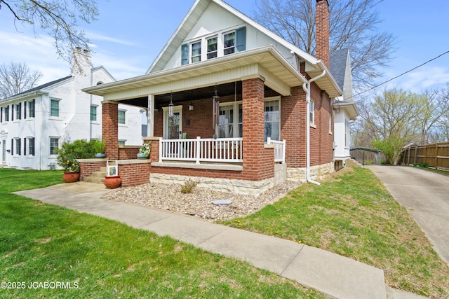 1400 W Main St, Jefferson City, MO 65101 - view of front of home featuring covered porch, concrete driveway, brick siding, and a chimney