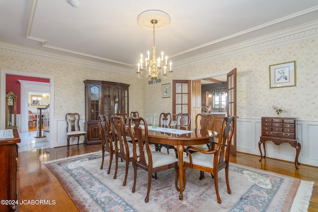 dining space featuring a chandelier, wood-type flooring, and ornamental molding