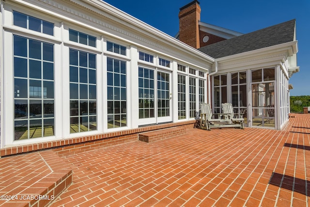 back of property with a patio and a sunroom