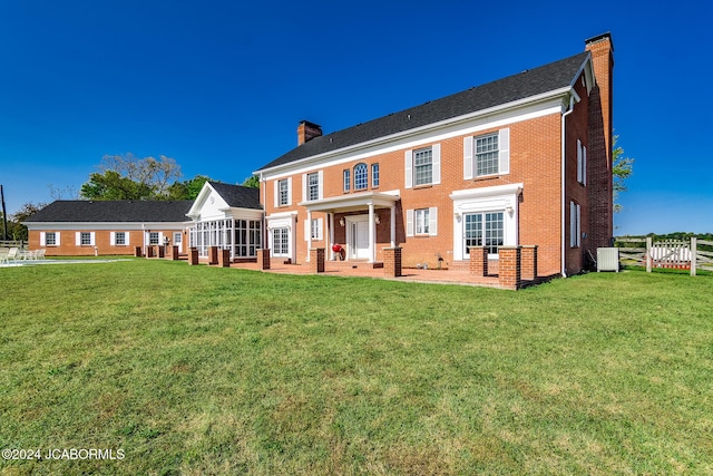 back of property featuring a lawn