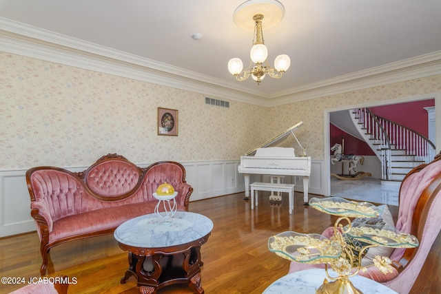 living room featuring hardwood / wood-style floors, ornamental molding, and a notable chandelier