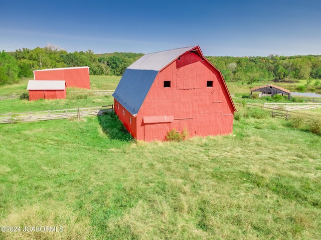 view of outdoor structure with a rural view and a yard