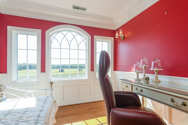 bedroom with light hardwood / wood-style flooring, multiple windows, and ornamental molding