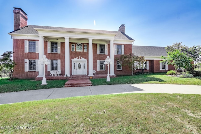 greek revival inspired property with a front lawn