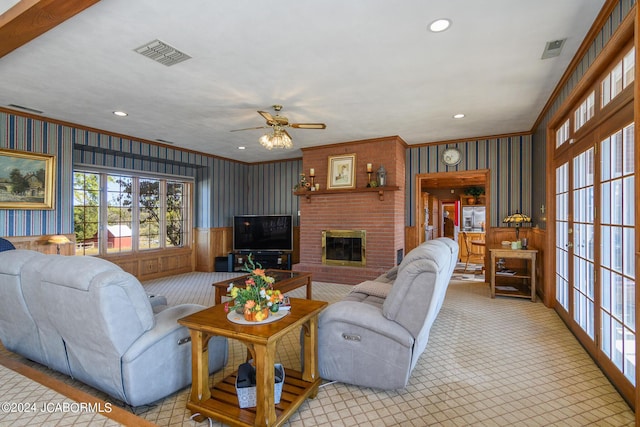 living room featuring a fireplace, ceiling fan, and ornamental molding