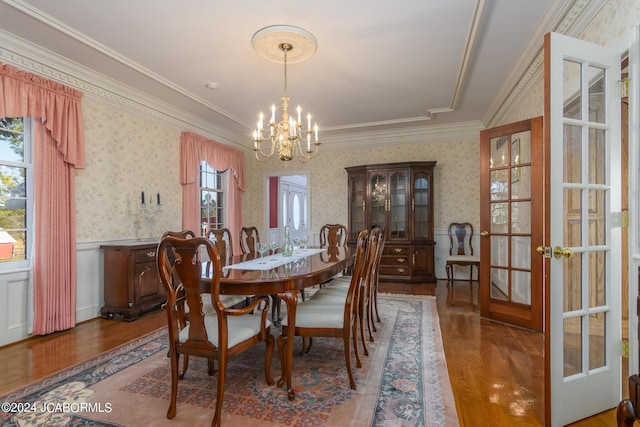 dining room featuring a chandelier, french doors, ornamental molding, and wood-type flooring