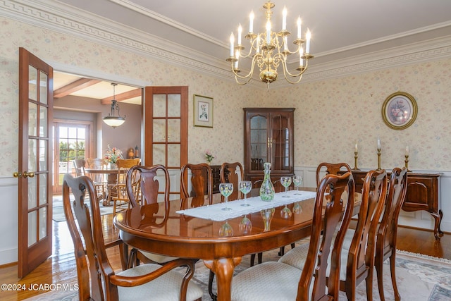 dining space with hardwood / wood-style floors, ornamental molding, and french doors