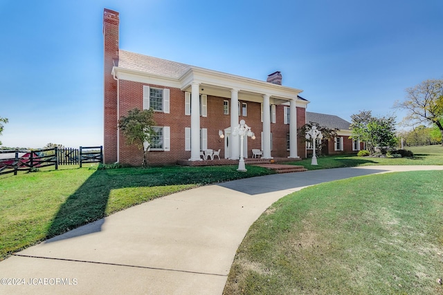 neoclassical home featuring a front yard