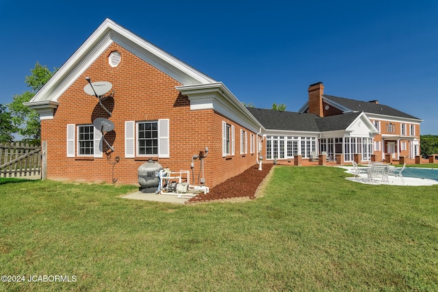 back of house featuring a patio and a lawn