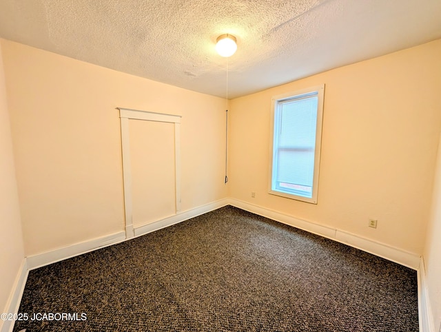 carpeted empty room with a textured ceiling
