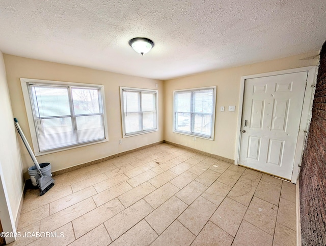 entrance foyer featuring a textured ceiling and a wealth of natural light