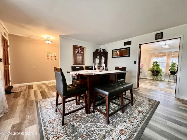 dining room with hardwood / wood-style floors and ornamental molding