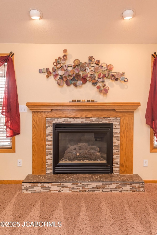 room details with carpet floors, baseboards, and a tiled fireplace