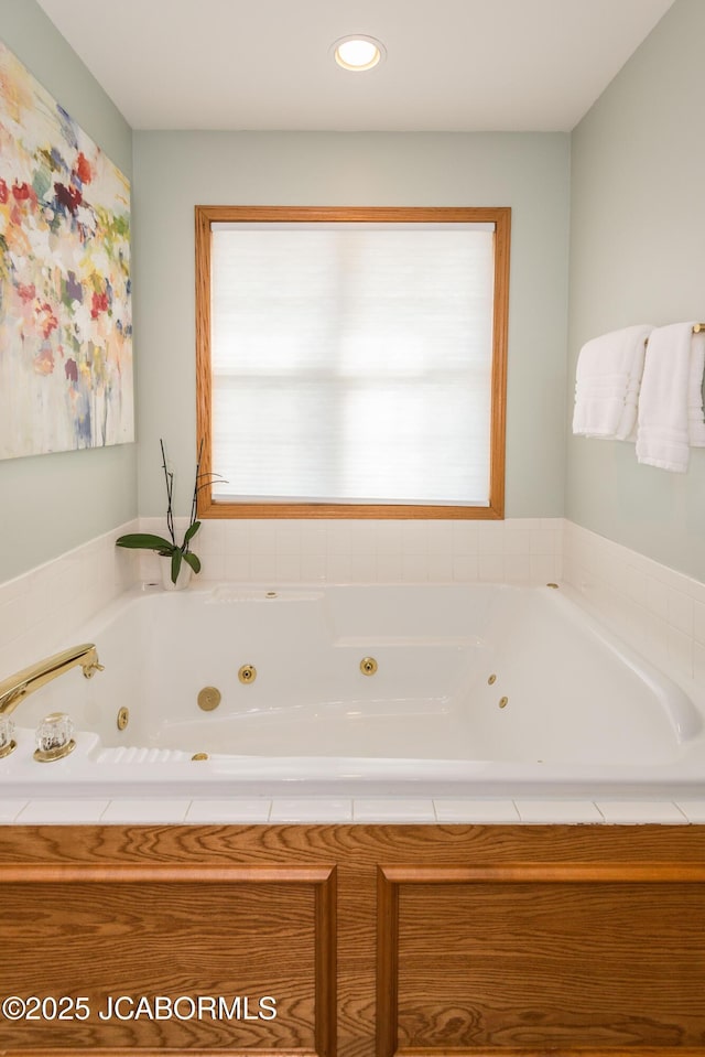 bathroom featuring a jetted tub and plenty of natural light