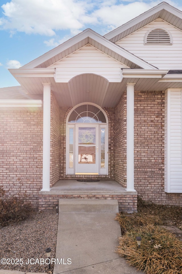 view of exterior entry with brick siding