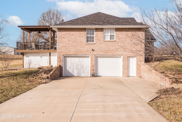 exterior space featuring a garage, concrete driveway, brick siding, and a shingled roof