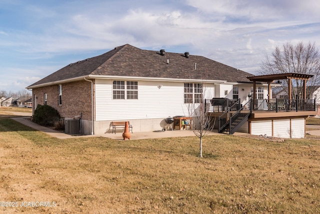 rear view of property with a patio, a yard, brick siding, and central air condition unit