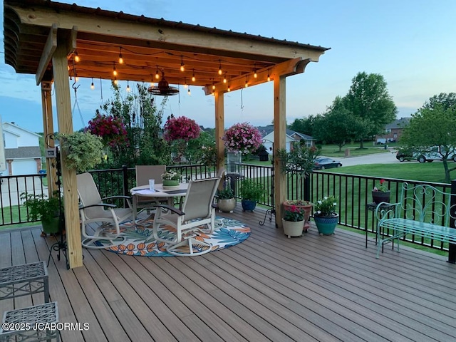 wooden terrace with outdoor dining area and a yard