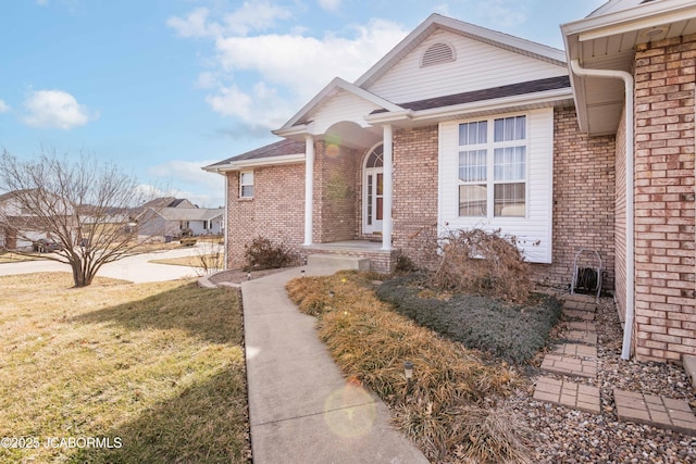 view of front of property featuring a front yard and brick siding