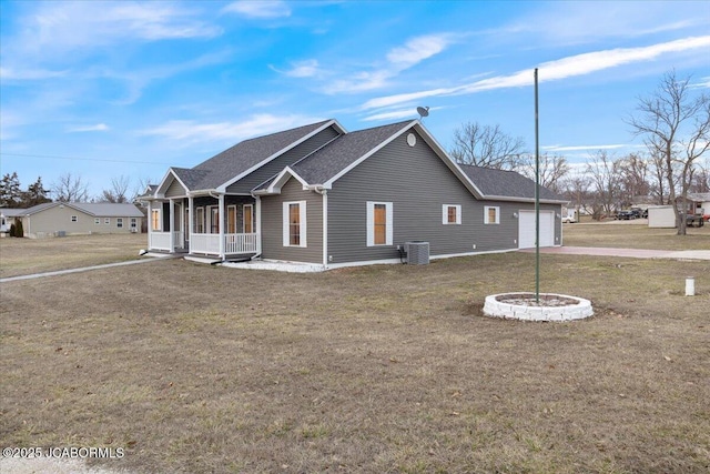 view of property exterior with a shingled roof, a lawn, an attached garage, a porch, and central AC