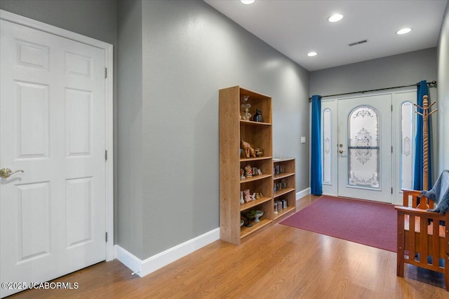 foyer entrance with baseboards, visible vents, wood finished floors, and recessed lighting