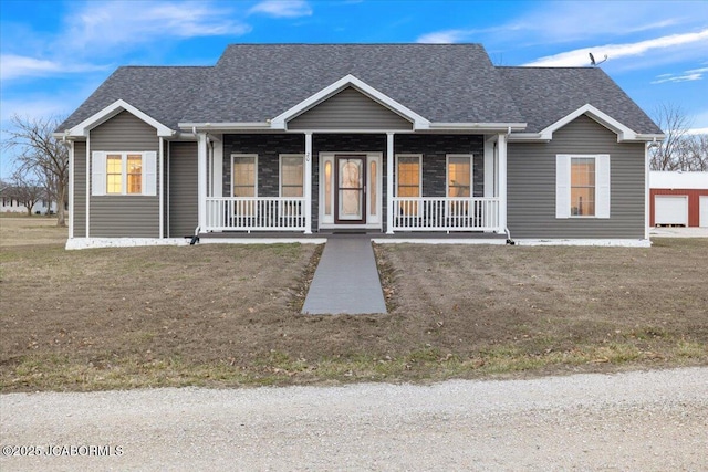 view of front of property with a shingled roof, a front yard, and covered porch