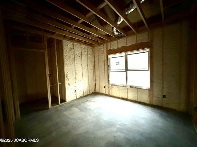 misc room featuring unfinished concrete floors and a garage