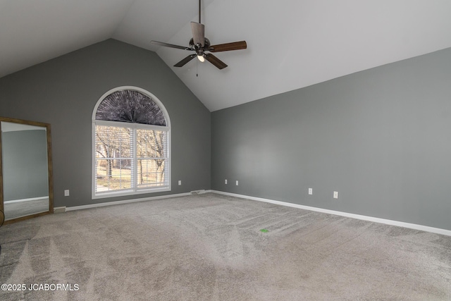 spare room featuring baseboards, carpet floors, high vaulted ceiling, and a ceiling fan