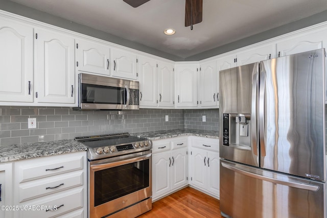 kitchen featuring backsplash, white cabinetry, and stainless steel appliances