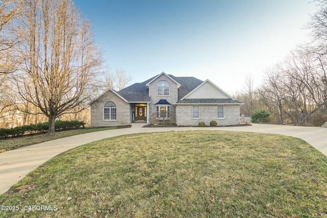 traditional-style home with curved driveway, a shingled roof, and a front lawn