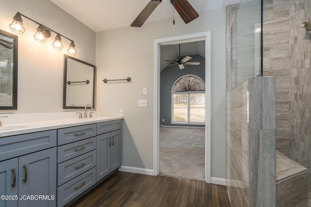 full bath with a sink, double vanity, and a ceiling fan