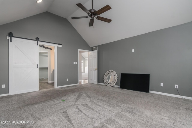 unfurnished living room with visible vents, ceiling fan, a barn door, carpet floors, and high vaulted ceiling