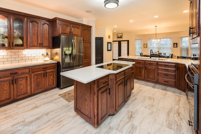 kitchen with pendant lighting, crown molding, backsplash, stainless steel appliances, and a center island