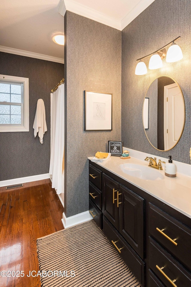 bathroom featuring vanity, crown molding, and wood-type flooring