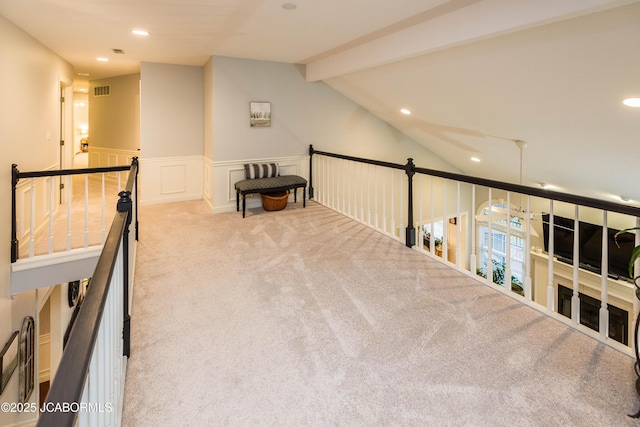 hallway featuring lofted ceiling with beams and light colored carpet