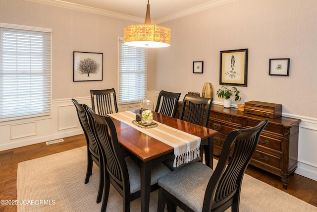 dining space with ornamental molding and dark hardwood / wood-style floors