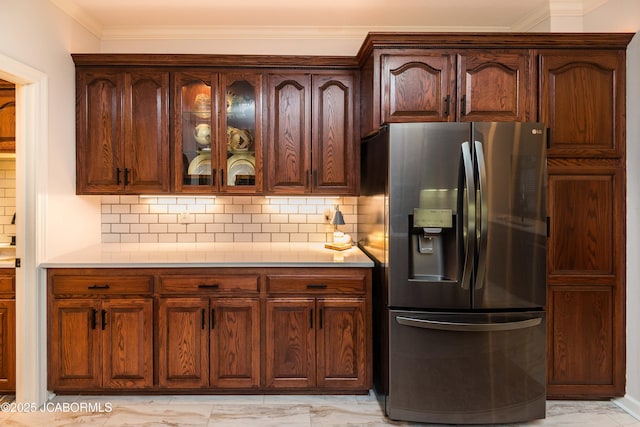 kitchen with ornamental molding, stainless steel fridge with ice dispenser, and decorative backsplash