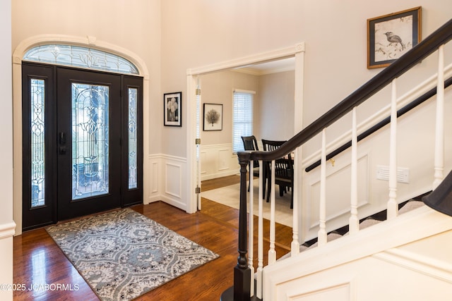 entrance foyer featuring crown molding, plenty of natural light, and dark hardwood / wood-style floors