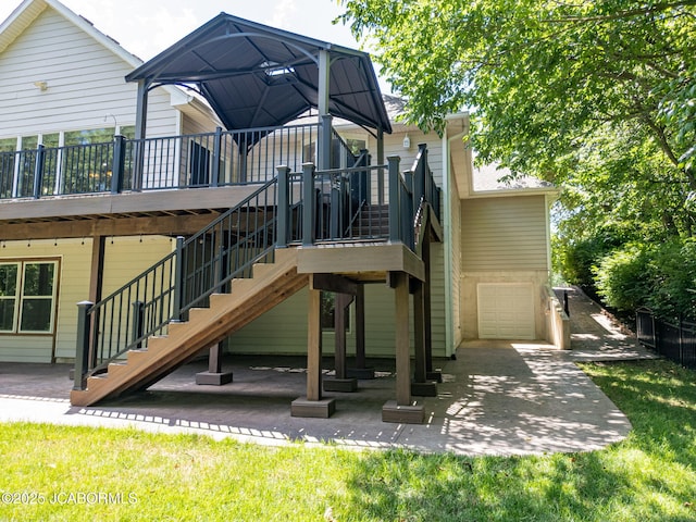 4205 Grant Ln, Columbia, MO 65203 - back of property featuring stairway, a deck, a patio, and an attached garage
