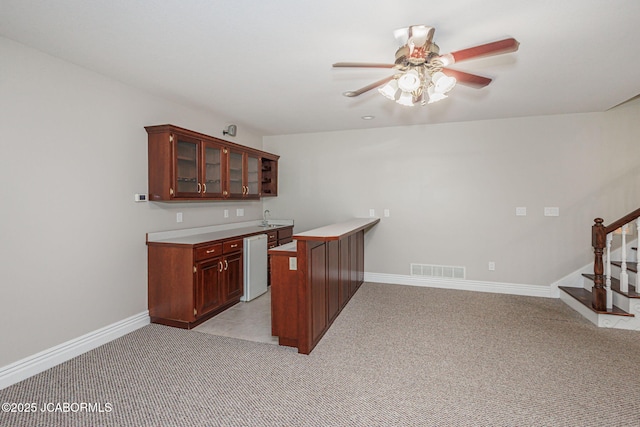 4205 Grant Ln, Columbia, MO 65203 - kitchen featuring ceiling fan, light carpet, dishwasher, glass insert cabinets, and a peninsula