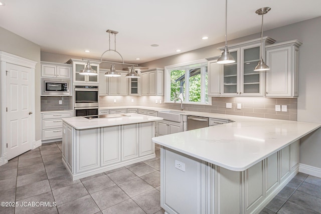4205 Grant Ln, Columbia, MO 65203 - kitchen with appliances with stainless steel finishes, glass insert cabinets, light countertops, backsplash, and recessed lighting